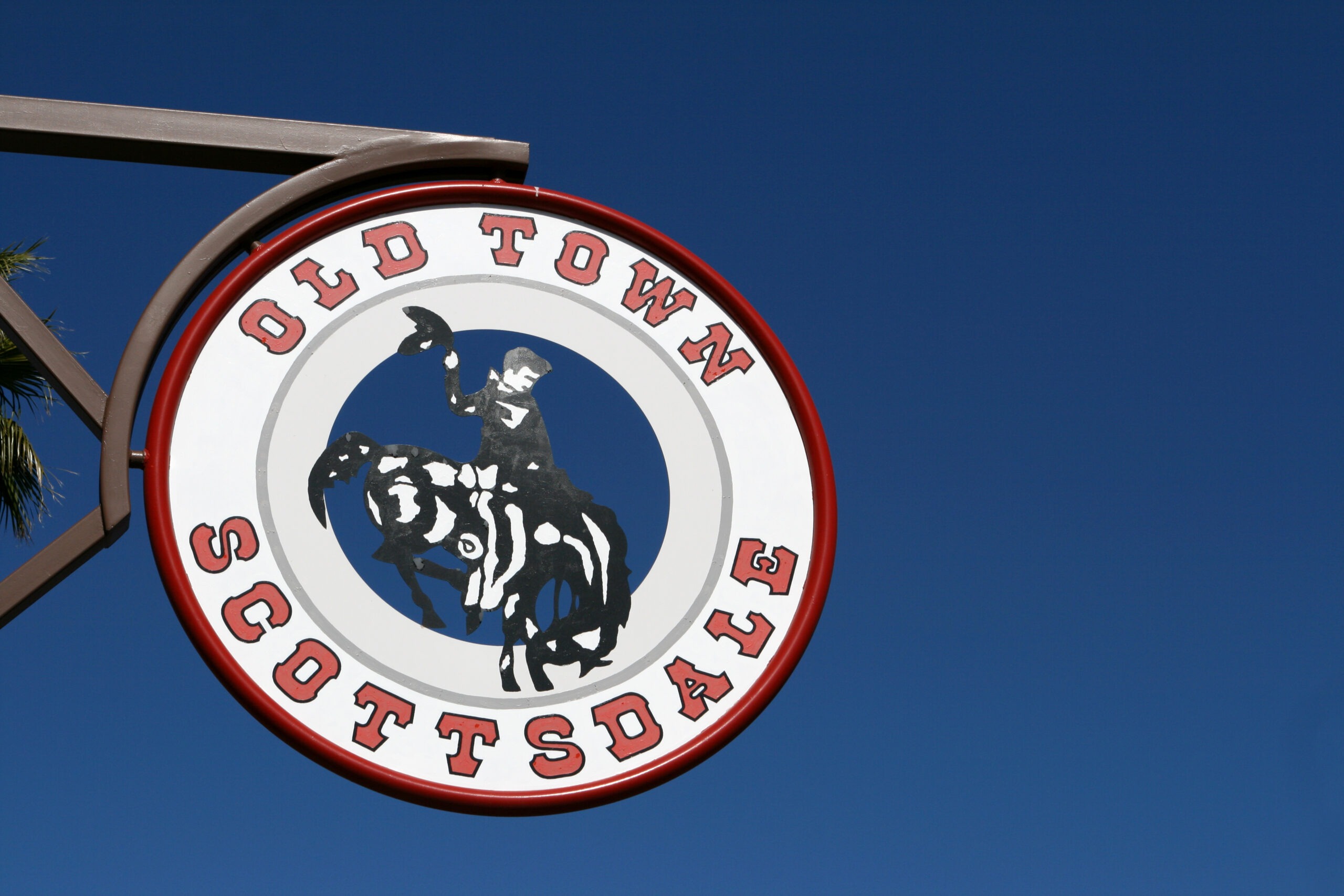 A sign reading "Old Town Scottsdale" with an image of a cowboy on a horse against a clear blue sky.