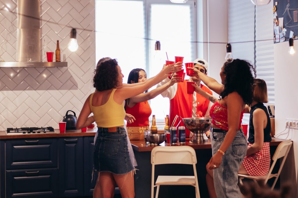 Group of friends raising a toast in a kitchen during a bachelor party